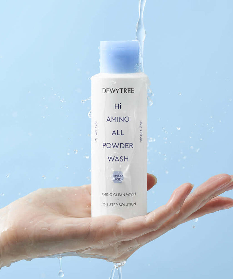 DEWYTREE Hi Amino All Enzyme Powder Wash 50g in hand with water splashing on the bottle, clean skincare product display.