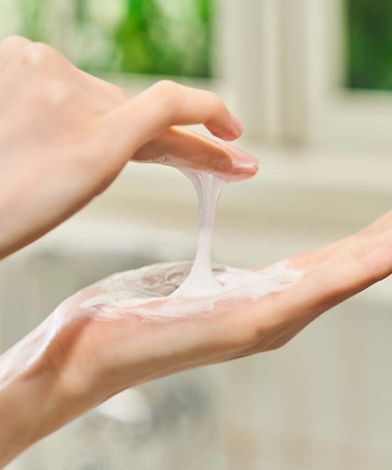 Applying DEWYTREE Hi Amino All Enzyme Powder Wash 50g on hand with creamy texture focus