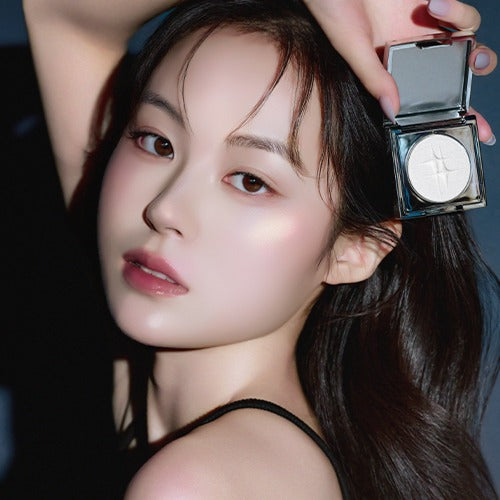 Person holding DINTO Polaris Shine Highlighter, highlighting radiant skin glow. Focus on makeup product with elegant packaging.