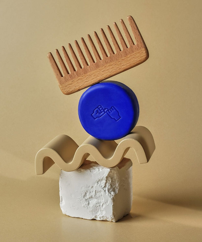 Wooden comb and DONGGUBAT Correct Shampoo Bar Cooling elegantly arranged on natural stone