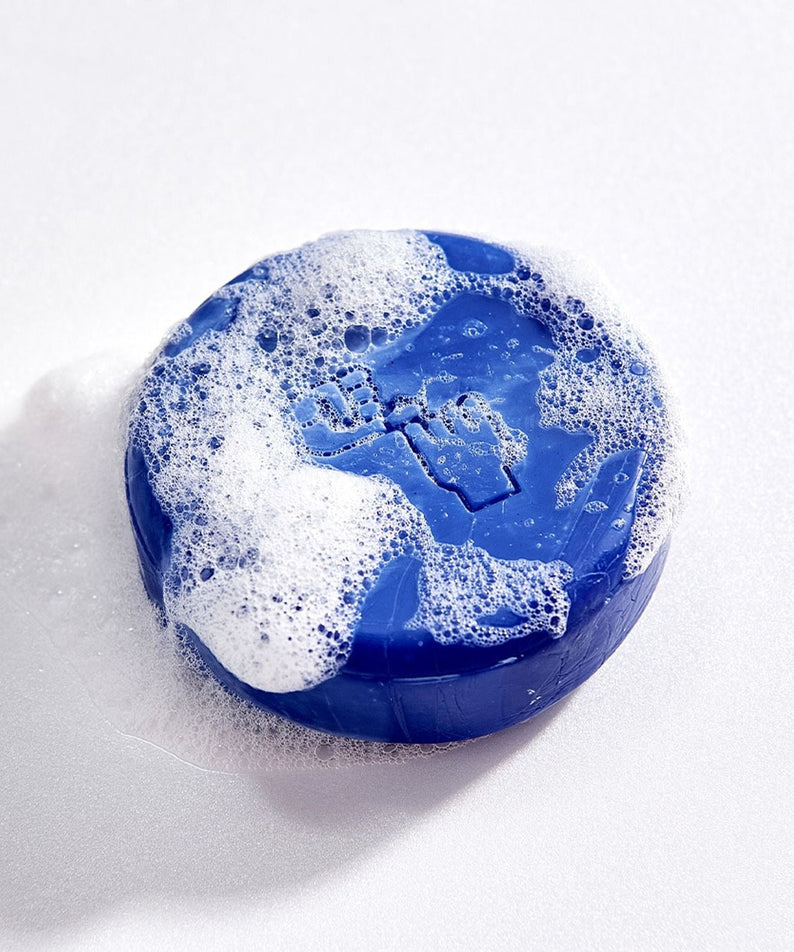 DONGGUBAT Correct Shampoo Bar Cooling with bubbles, blue round soap bar on white background