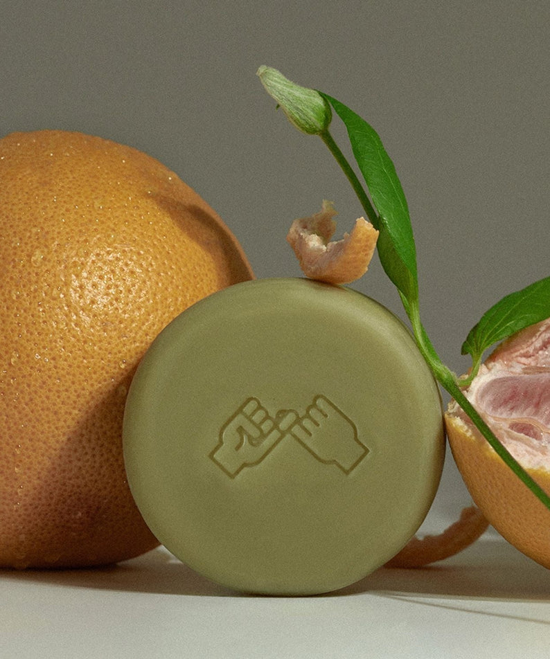 DONGGUBAT Correct Shampoo Bar For Dry Skin next to fresh grapefruit, illustrating its natural ingredients and eco-friendly appeal.