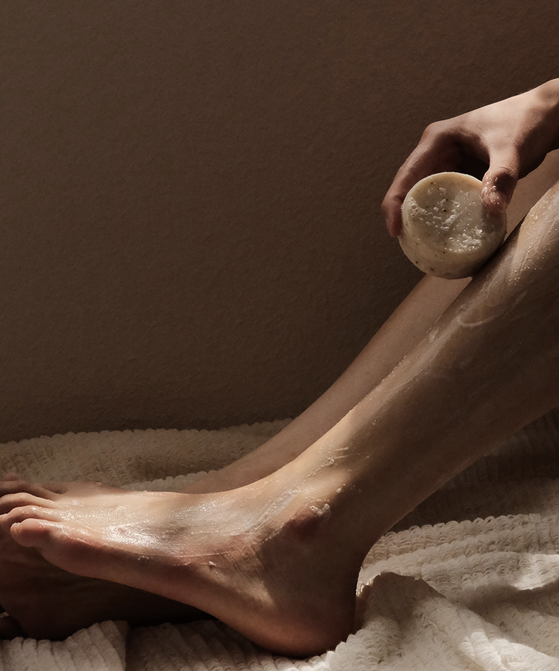 Person using DONGGUBAT Field Correct Body Soap Noni on leg for skincare.