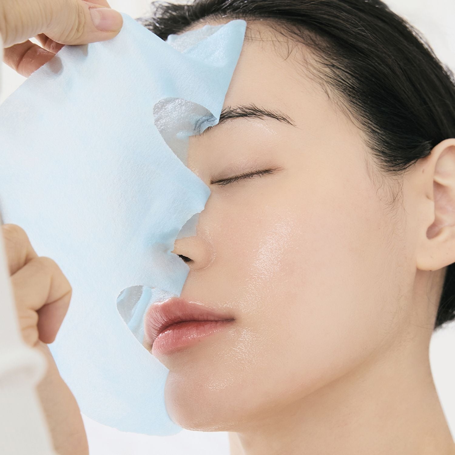 Person applying DR.ALTHEA Aqua Blue Hydrating Mask (4ea) for hydration and skin rejuvenation; skincare routine.