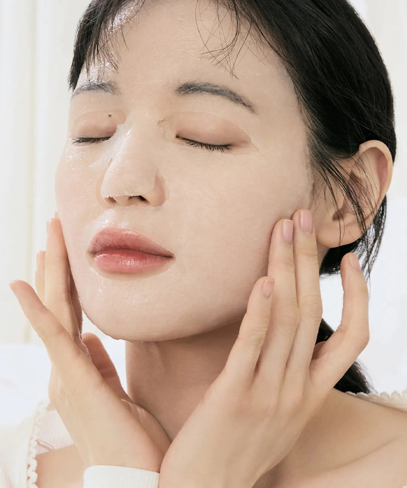 Woman applying DR.ALTHEA Jelly Seal Dewy Mask (4ea) for a hydrated skincare routine in elegant, serene setting.