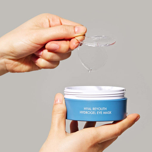 Hands holding DR.CEURACLE Hyal Reyouth Hydrogel Eye Mask 90g 60p with open lid showing hydrogel patches.