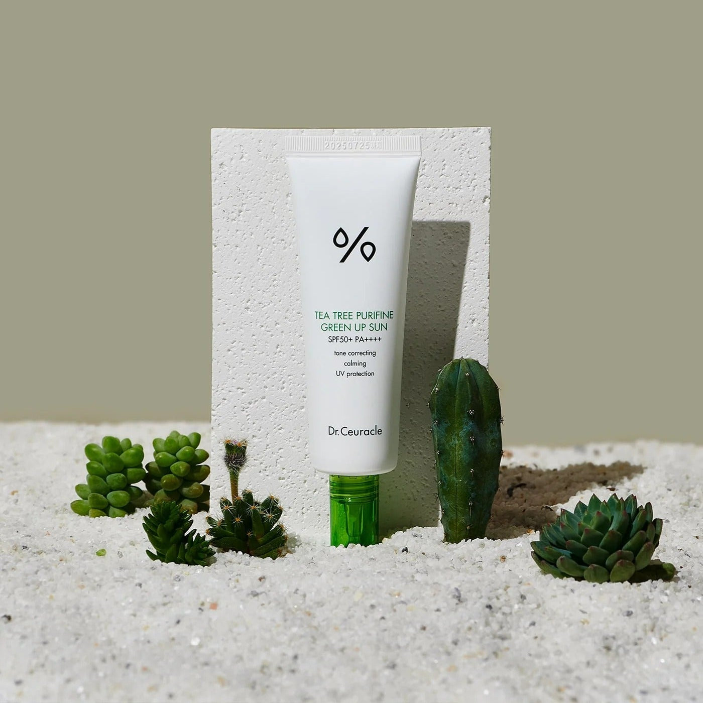 DR.CEURACLE Tea Tree Purifine Green Sup Sun 50ml sunscreen with greenery in sand background