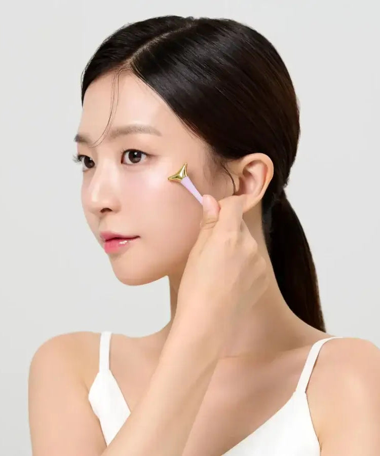 Woman applying DR.CEURACLE Vegan Active Berry Firming Eye Cream to cheek with roller