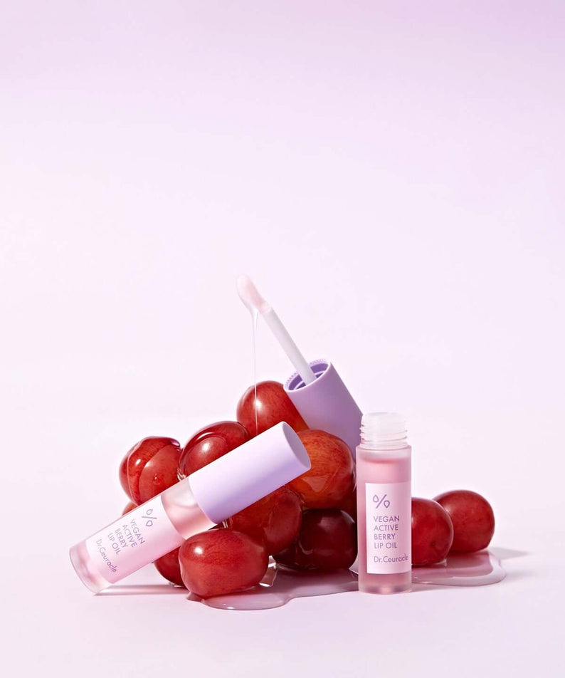 DR.CEURACLE Vegan Active Berry Lip Oil with grape background showcasing natural ingredients and hydrating formula.