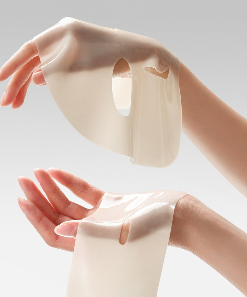 DR.CEURACLE Vegan Kombucha Tea Essence-in-Gel Mask being held between two hands, showcasing its texture and gel-like appearance.
