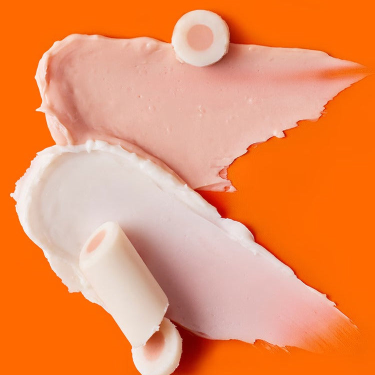 DR.JART+ Brightamine Brightening Eye Serum Stick texture and color swatch on orange background.