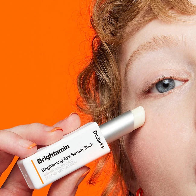 Close-up of DR.JART+ Brightamine Brightening Eye Serum Stick being applied under the eye for a radiant look.