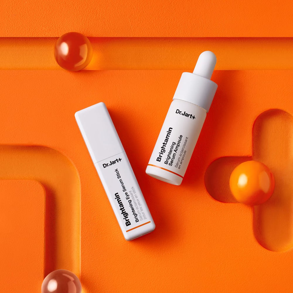 DR.JART+ Brightamine Brightening Serum Ampoule on vibrant orange background.