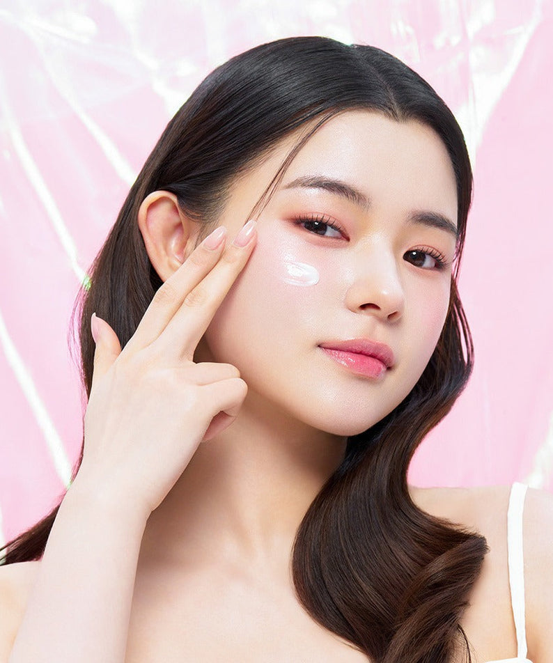 Model applying EDIT.B Veil On Skin Boosthing Prep 50ml to face against pink background