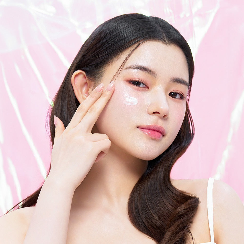 Model applying EDIT.B Veil On Skin Boosthing Prep 50ml to face against pink background