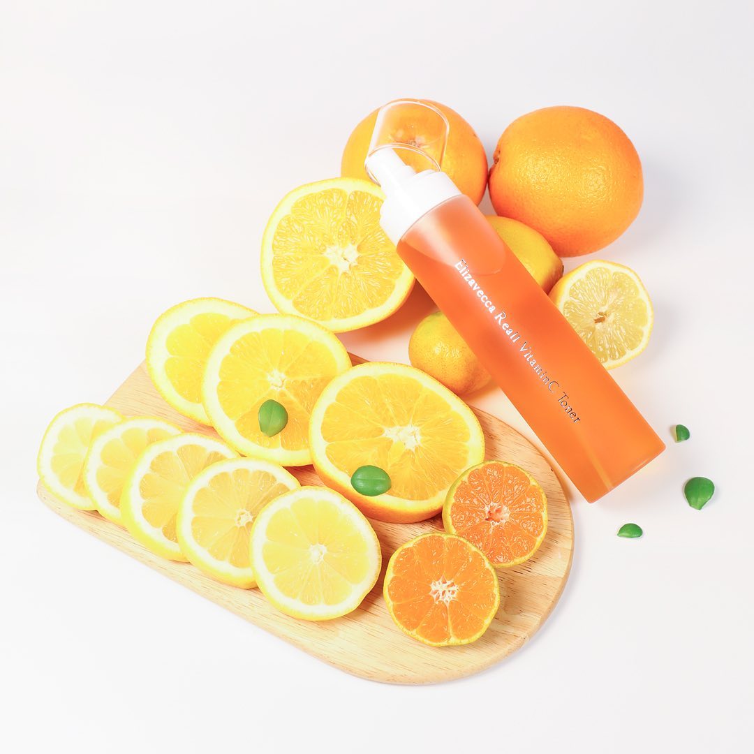 ELIZAVECCA Real One Vitamin C Toner 200ml bottle with citrus fruits on wooden board, promoting freshness and skincare benefits