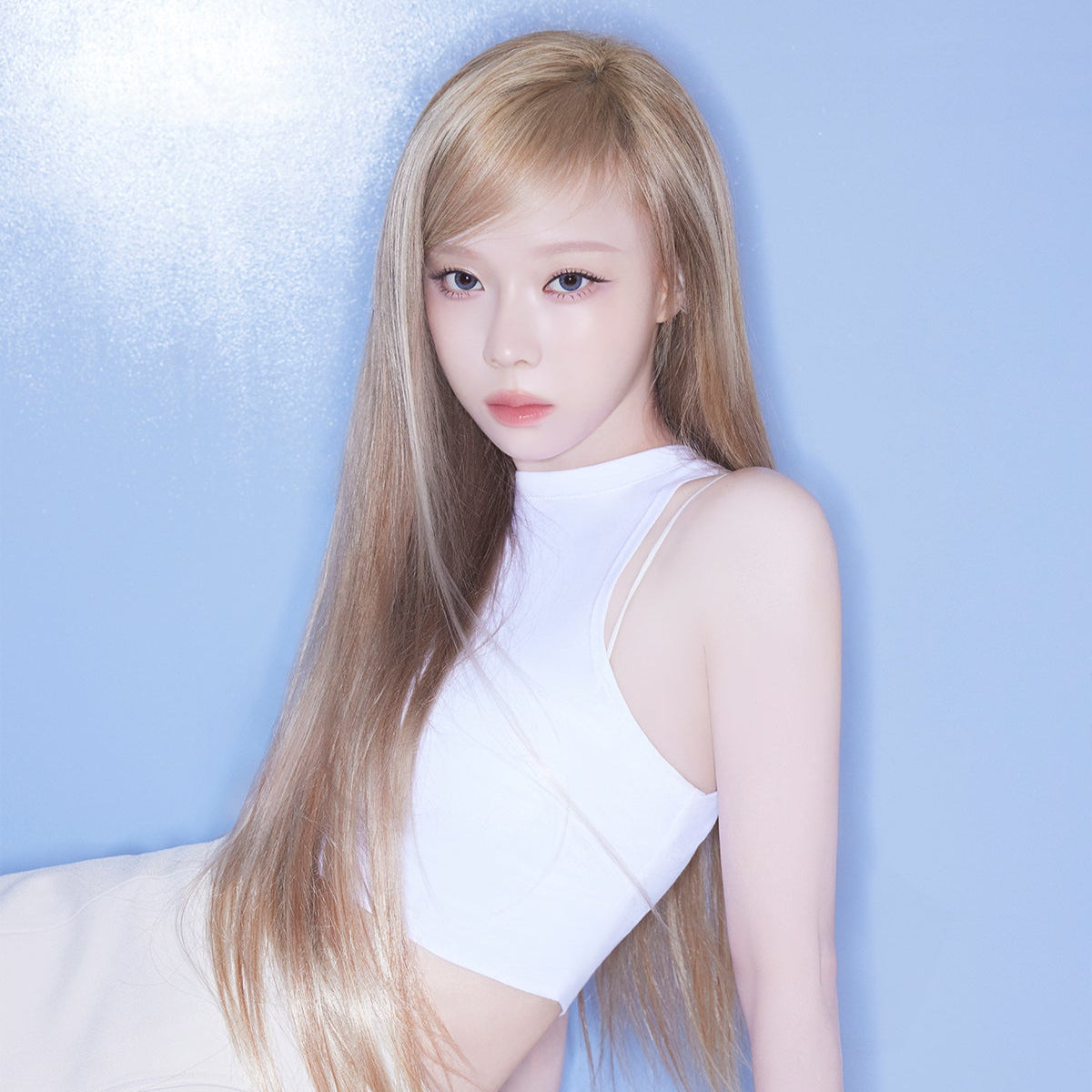 Stylish woman posing in a white top against a blue background