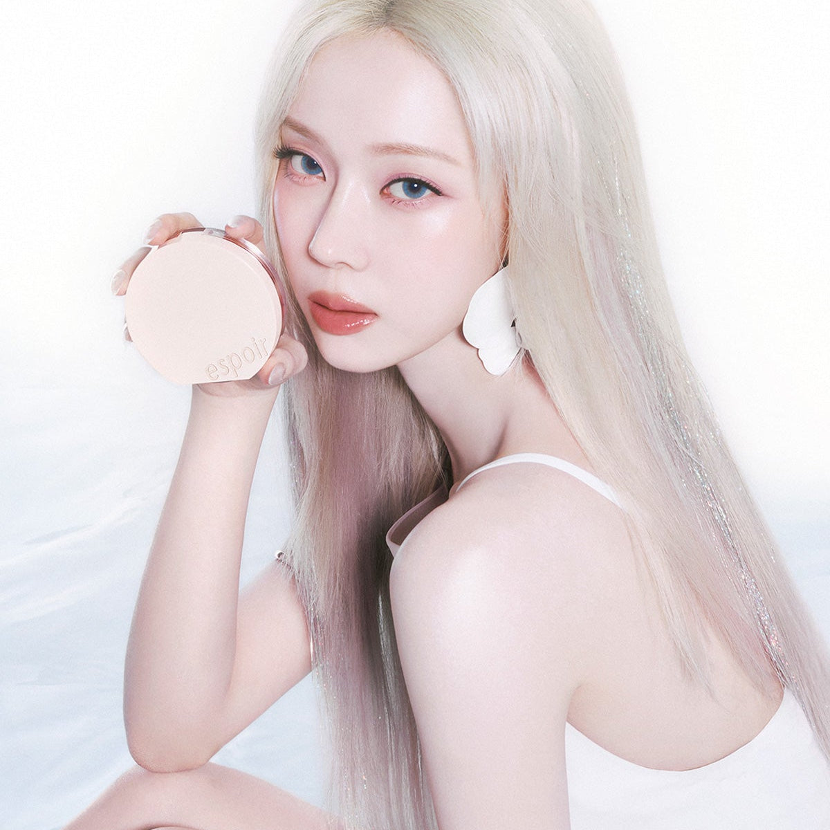 Model holding ESPOIR BE GLOW VOLUME CUSHION SPF42 PA+++ with radiant skin, emphasizing the product's glow-enhancing properties.