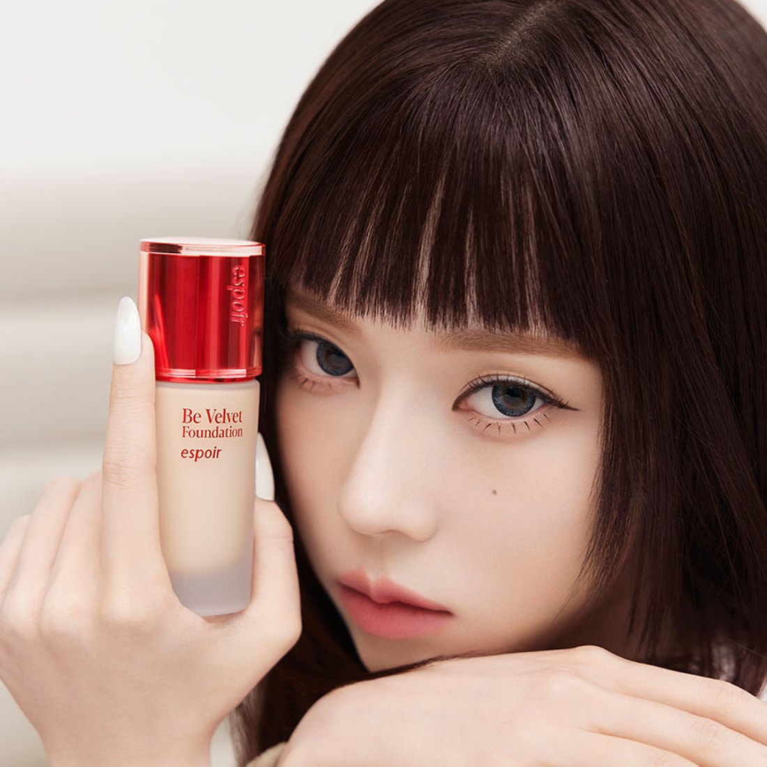 Woman holding ESPOIR BE VELVET FOUNDATION SPF22 PA++ bottle