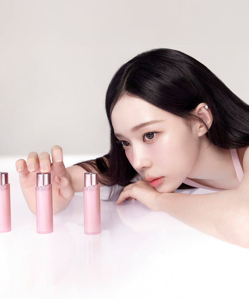 Model with ESPOIR Bare Glow Lip Balm showcasing pink packaging.