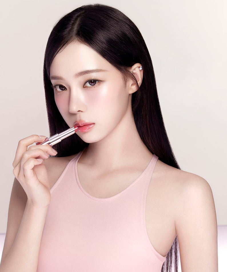 Woman applying ESPOIR Bare Glow Lip Balm for a subtle shine and hydration.