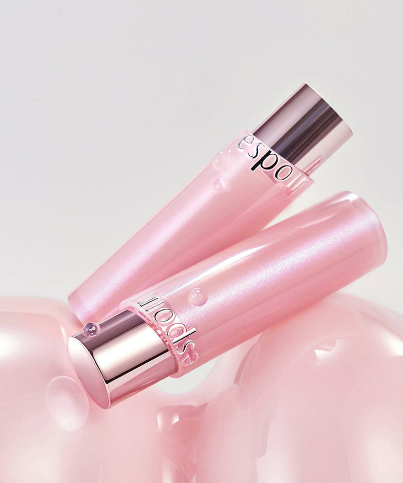 ESPOIR Bare Glow Lip Balm in pink packaging on a glossy surface, showcases luxurious and moisturizing qualities.