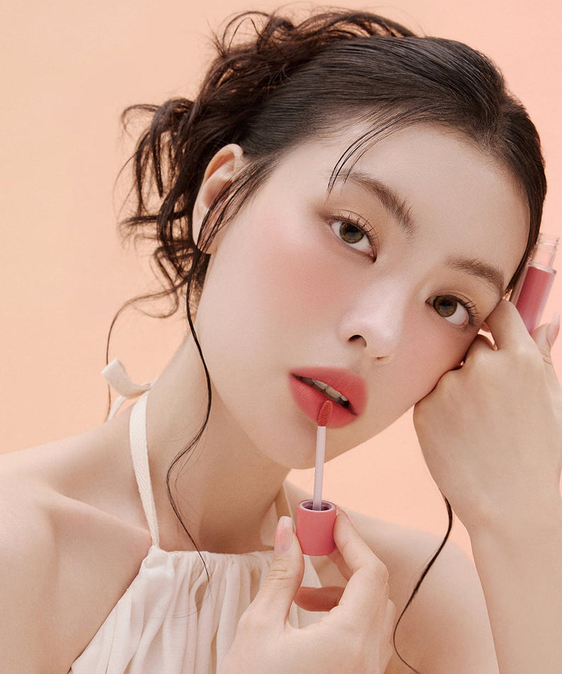 Woman applying ESPOIR Couture Lip Tint Fitting Blur for a natural, soft look.