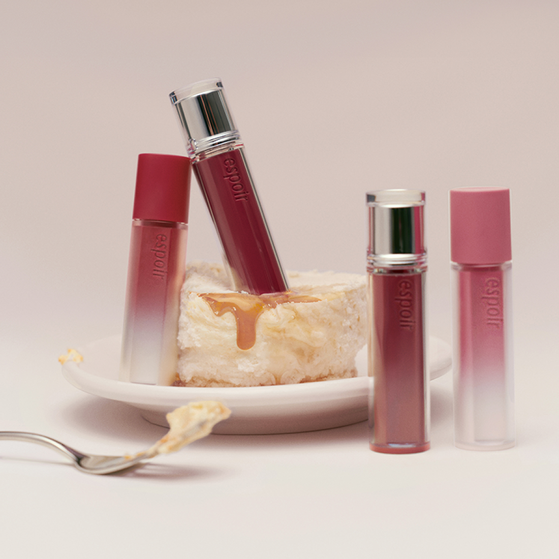 ESPOIR Couture Lip Tint Glaze [NEW COLOR] tubes displayed innovatively with dessert background, showcasing the new color variant.