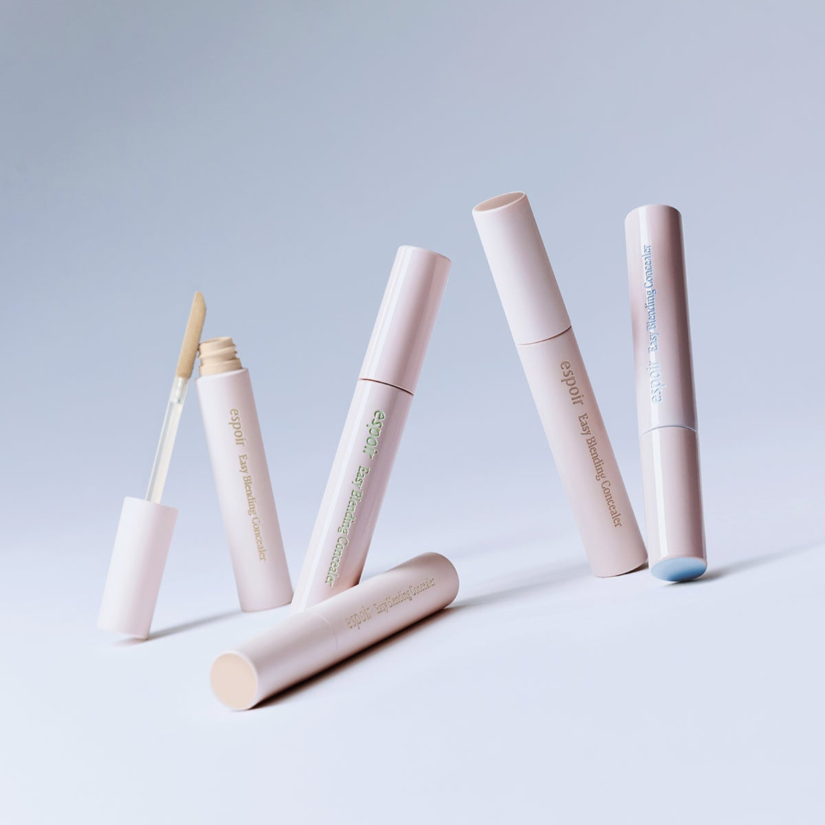 Four tubes of ESPOIR EASY BLENDING CONCEALER on a light background, showcasing their sleek design and applicator.