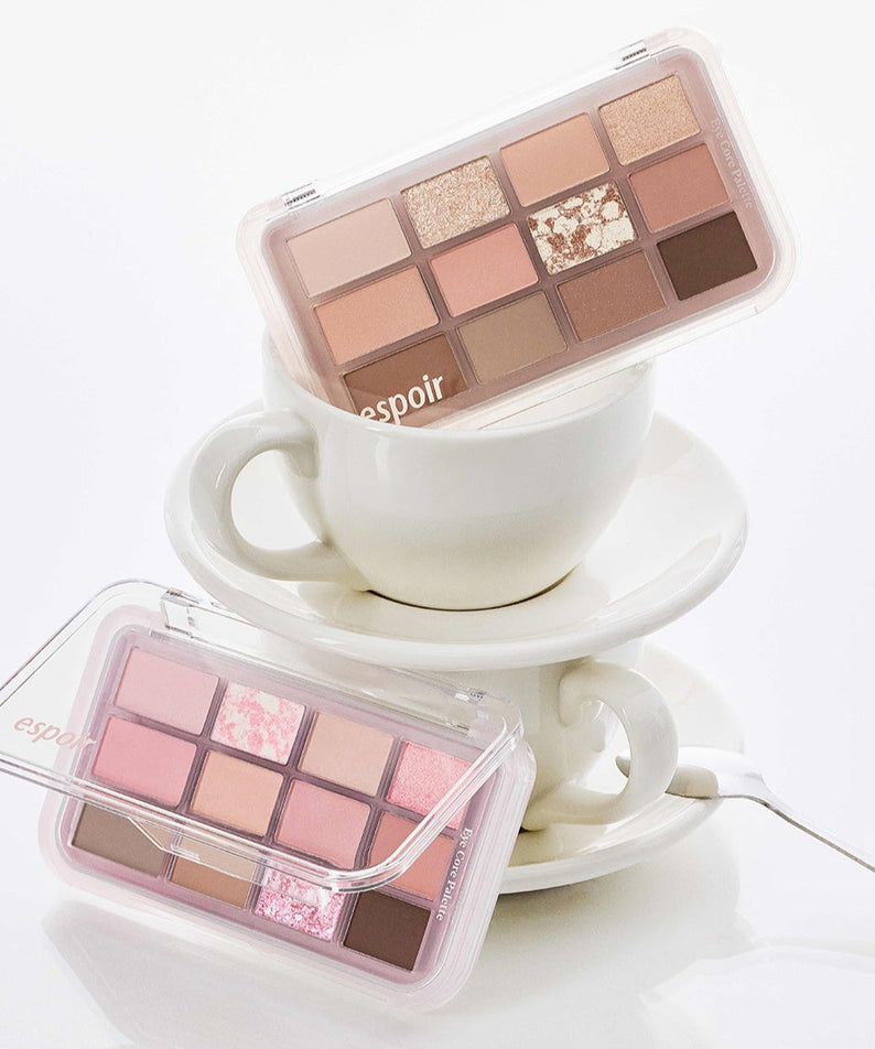 ESPOIR Eye Core Palette featuring a collection of warm and pink eyeshadows displayed on a stack of white teacups.