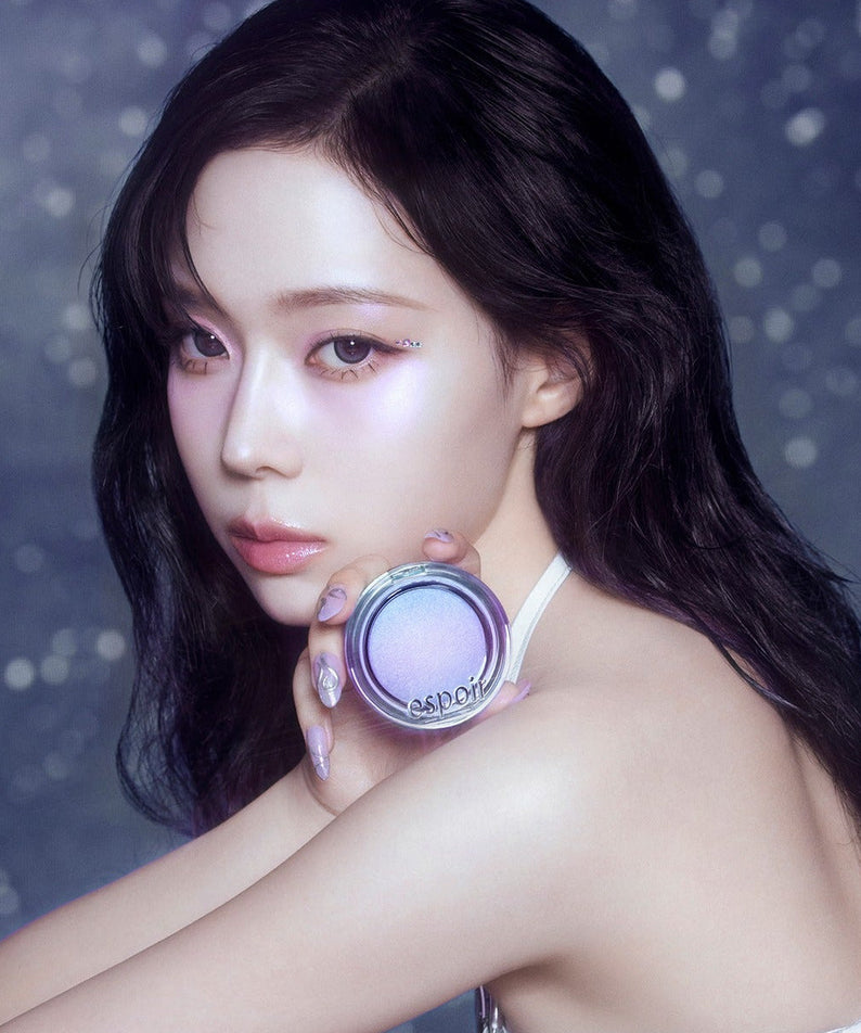 Woman holding ESPOIR Strobing Highlighter [Galaxy Beam Collection] with stars in background