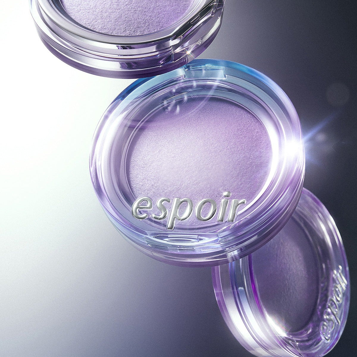 ESPOIR Strobing Highlighter [Galaxy Beam Collection] in a glowing purple shade, enhancing makeup with a radiant finish.