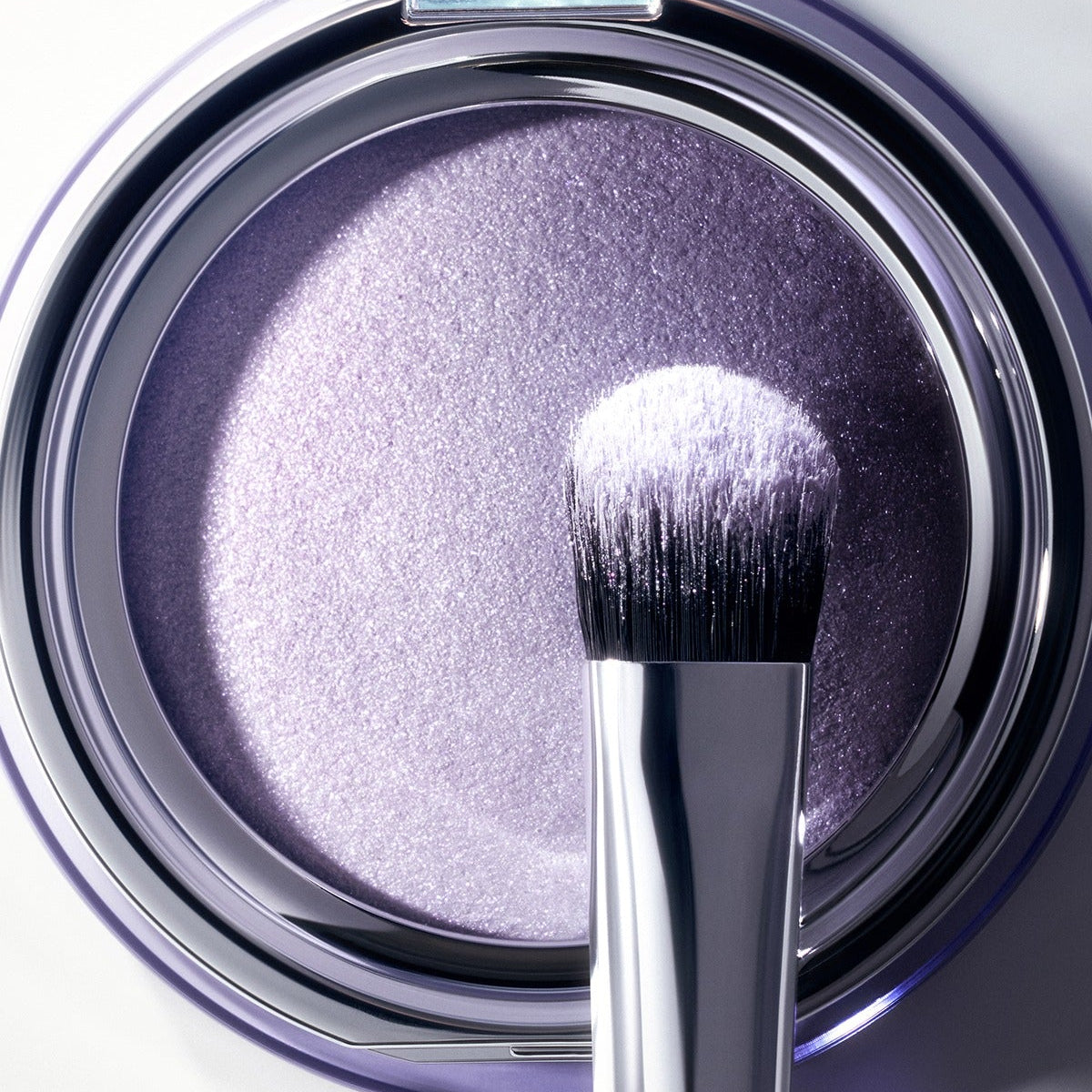 Close-up of ESPOIR Strobing Highlighter [Galaxy Beam Collection] with brush, highlighting its shimmering purple hue.