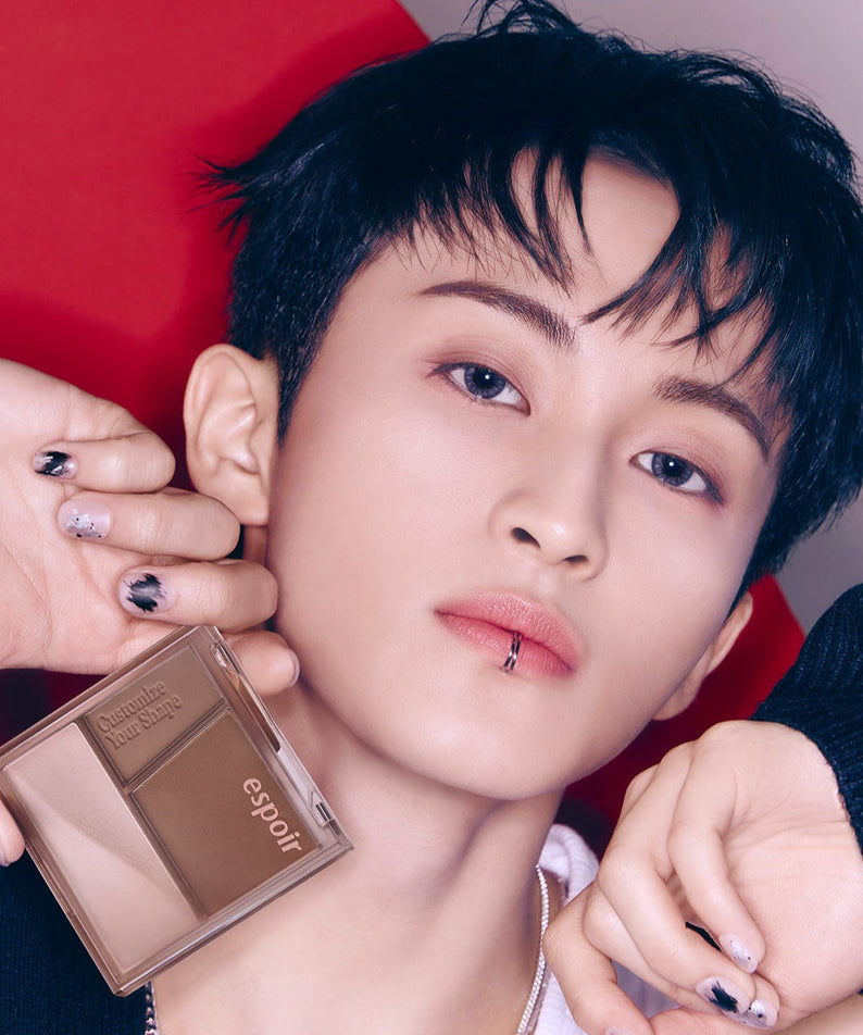 Person holding ESPOIR Tone Pairing Contour Palette in front of their face, showcasing the makeup product in a stylish manner.