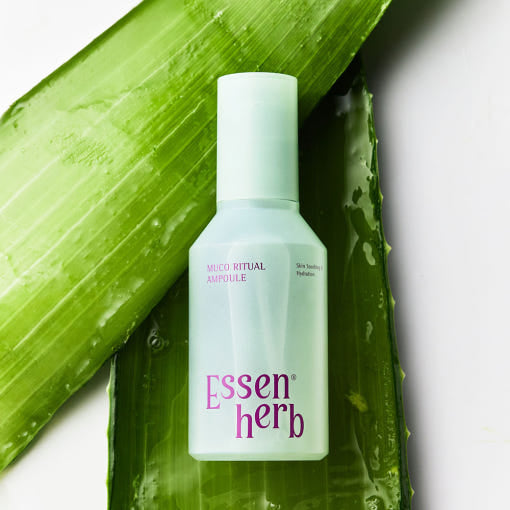 ESSENHERB Mucoritual Ampoule 120ml bottle on green leaf background for skincare