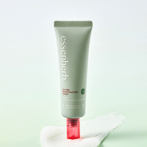 ESSENHERB Tea Tree Repair Solution Cream 50ml tube on a smooth surface