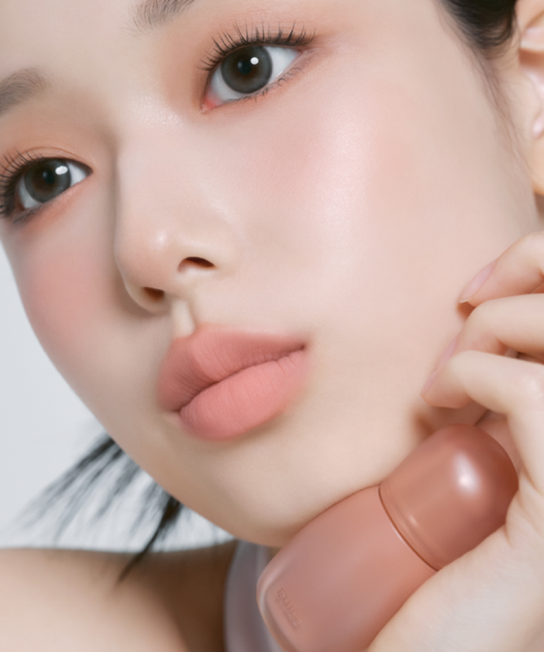 Model wearing ETUDE Cozy Fixing Tint 4g, showcasing a soft peach lip shade. Ideal for daily wear and long-lasting tint application.