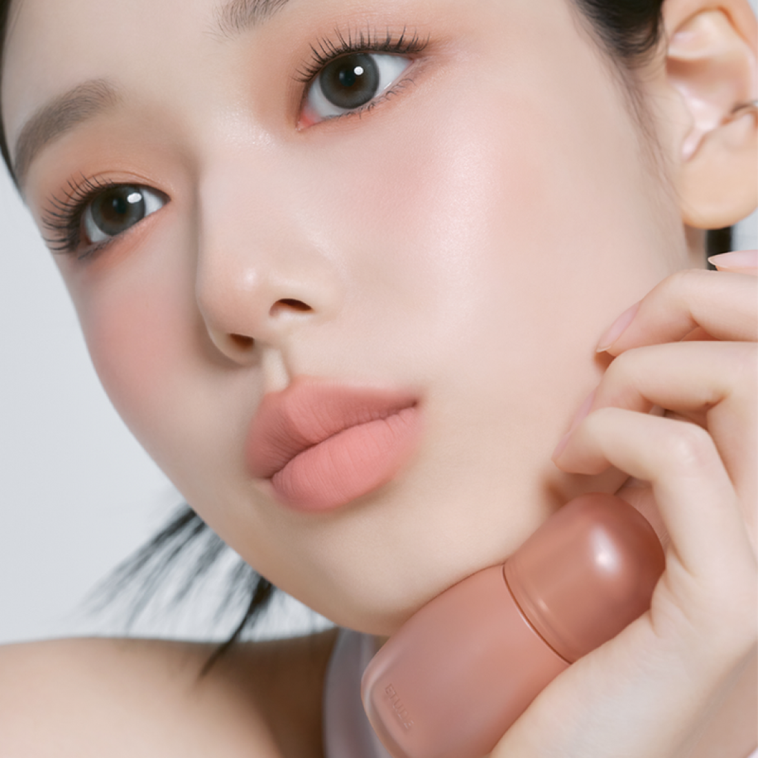 Model wearing ETUDE Cozy Fixing Tint 4g, showcasing a soft peach lip shade. Ideal for daily wear and long-lasting tint application.