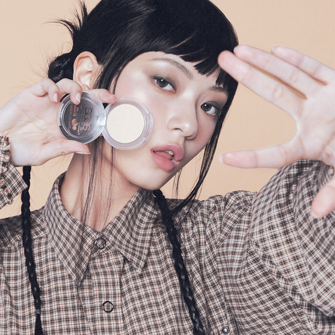 Model showcasing ETUDE Face Brightener product with edgy makeup look against neutral background.