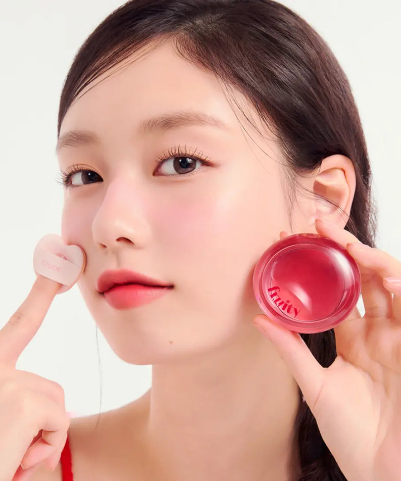 Model applying ETUDE Fruity Lip & Cheek Blur Balm 2.3g on cheek, showcasing vibrant color and smooth texture.
