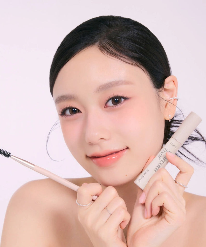 Woman holding ETUDE Pangpang Hair Cara Fixer 10ml with applicator, highlighting natural brow enhancement.
