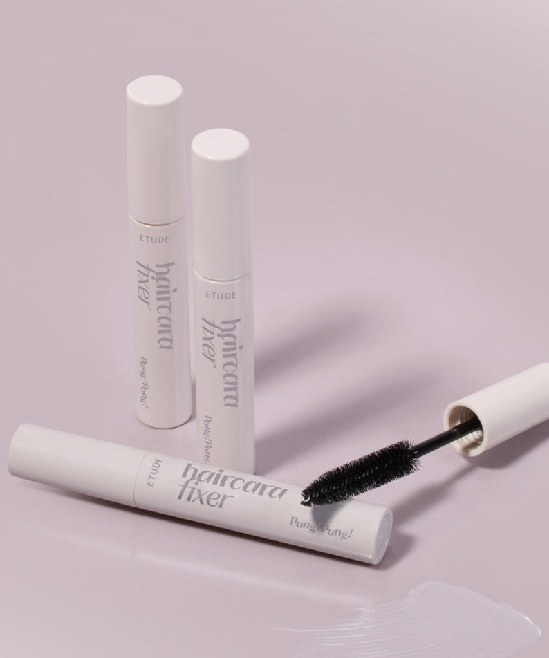 ETUDE Pangpang Hair Cara Fixer 10ml tube with wand against a soft pink background.