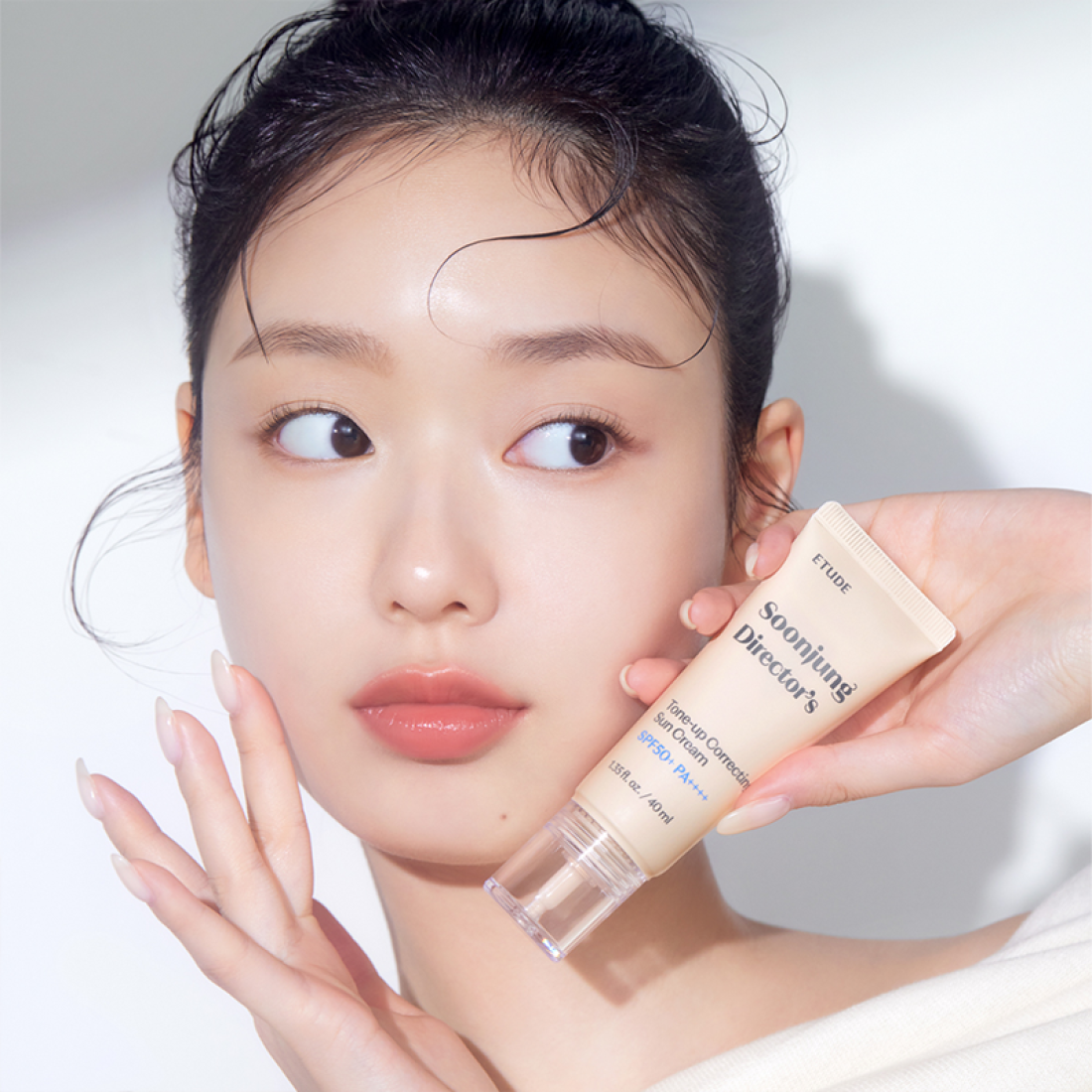 Woman holding ETUDE Pure Director Tone-Up Correction Sunscreen Planning Set SPF50+/PA++++ in her hand, showcasing product.