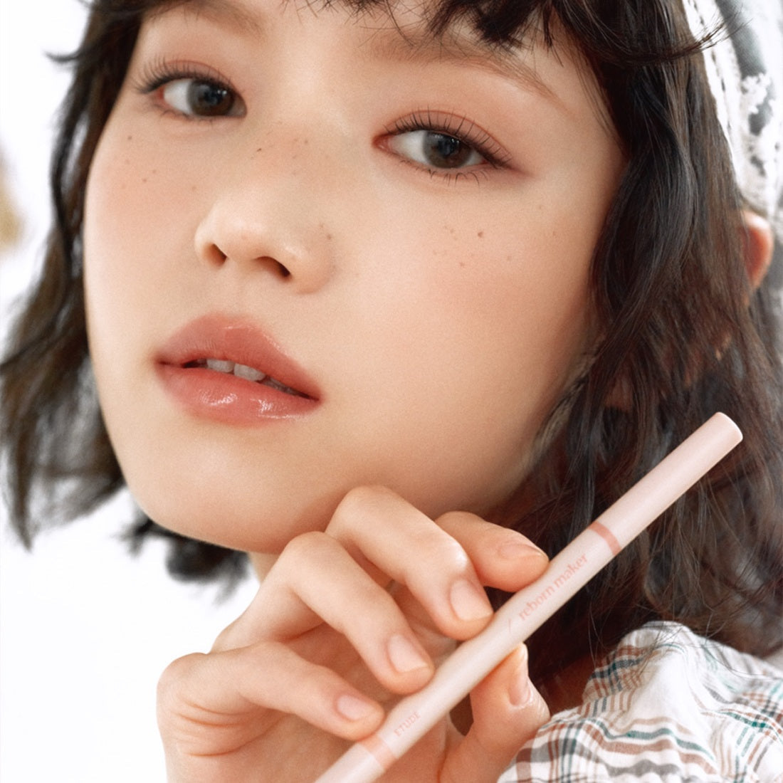Model holding ETUDE Re-creation Maker Aegyo-sal Liner for makeup enhancement