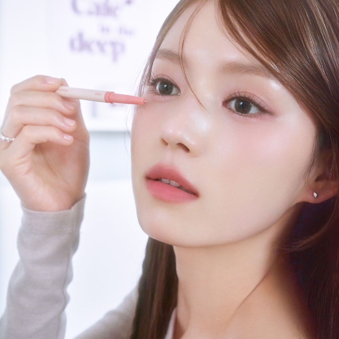 Woman applying ETUDE Re-creation Maker Aegyo-sal Liner under eyes for a youthful look.