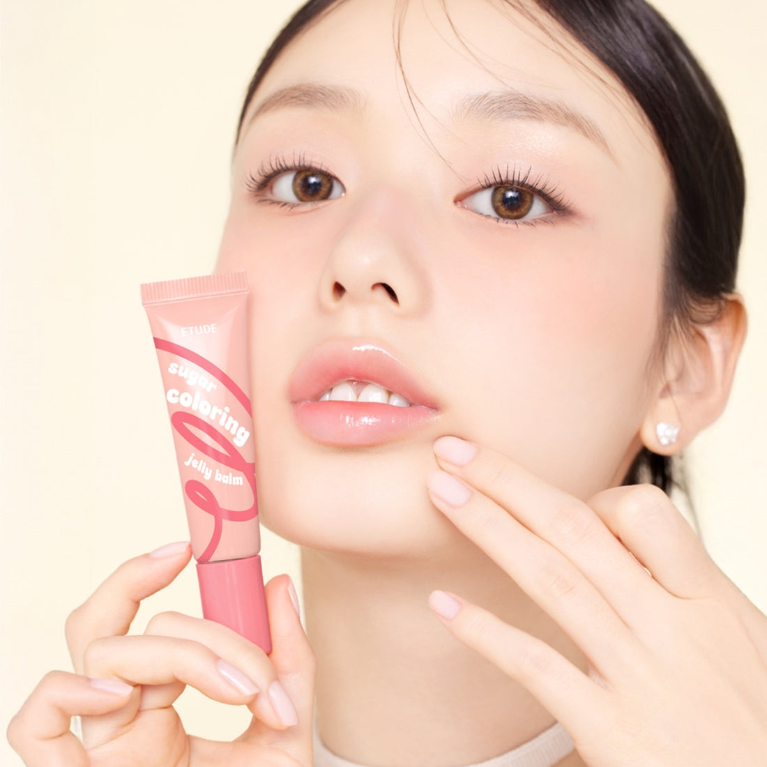 Model holding ETUDE Sugar Coloring Jelly Balm 9g showing moisturizing lip color.