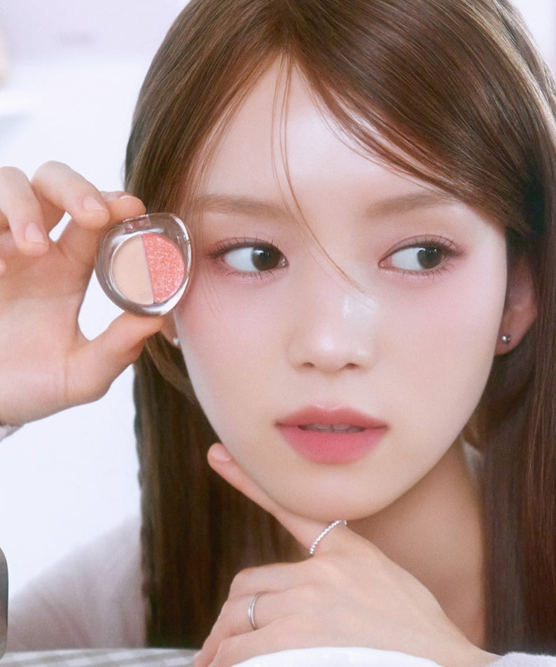 Woman holding ETUDE What's in My Eyes Cafe Double eyeshadow near her face.