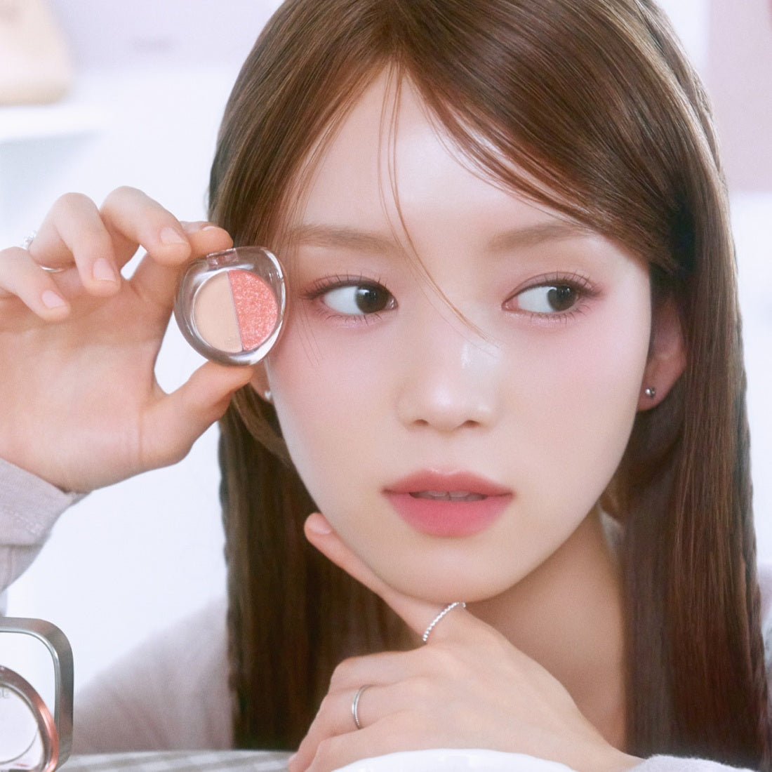 Woman holding ETUDE What's in My Eyes Cafe Double eyeshadow near her face.
