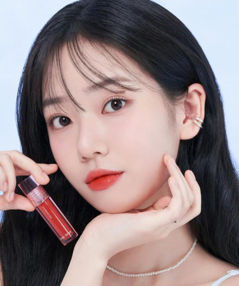 Woman holding FORENCOS Renewal Tattoo Tint with a soft makeup look.