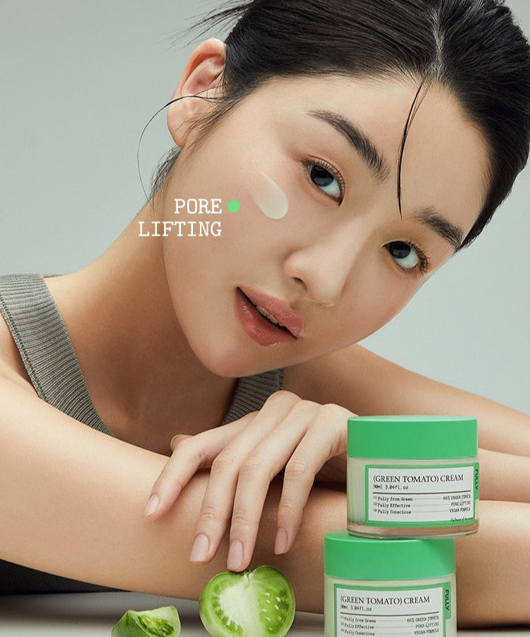 Model applying FULLY Green Tomato Cream 90ml with visible green tomato ingredients, promoting skin care benefits like pore lifting.